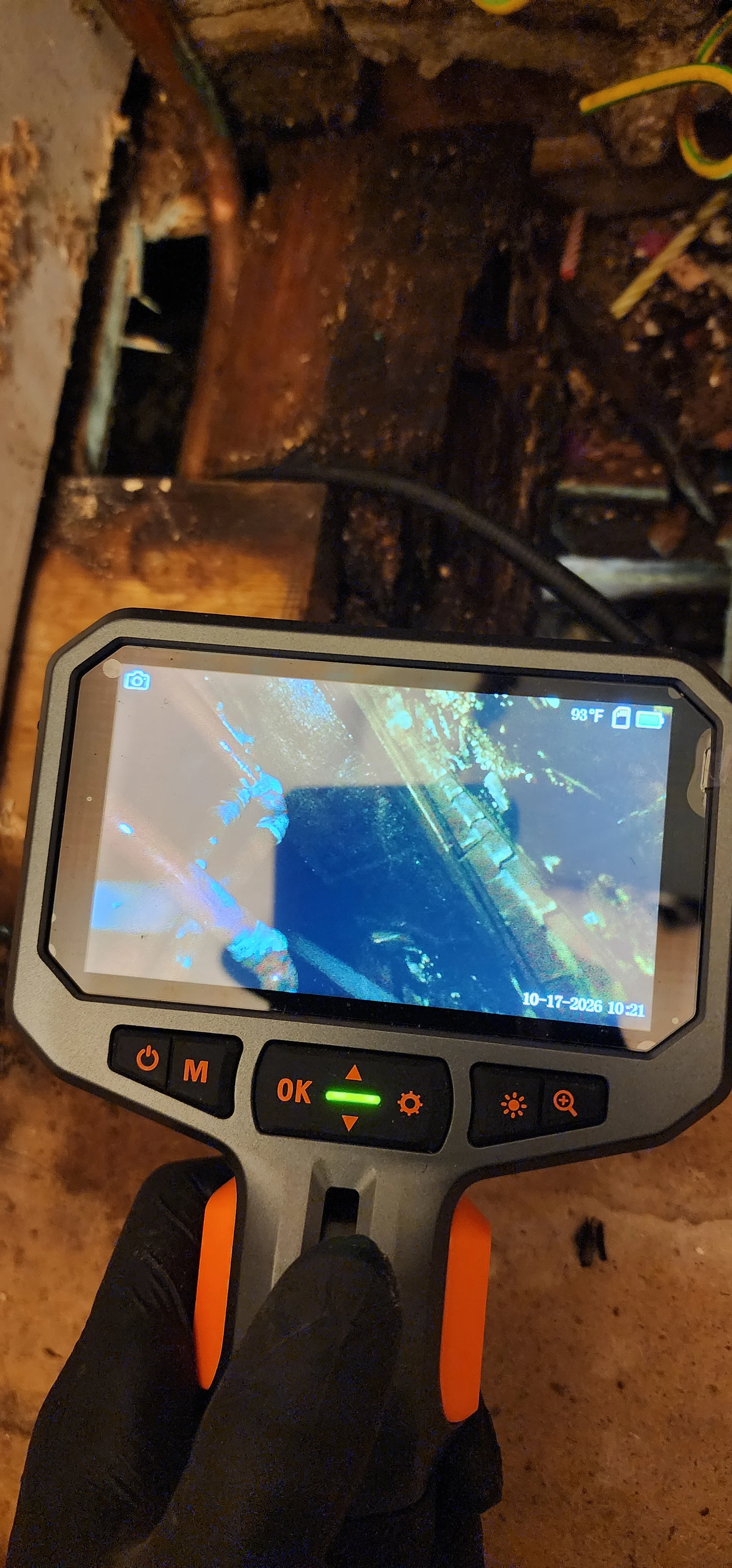 Handheld inspection camera displaying a close view inside the floor area