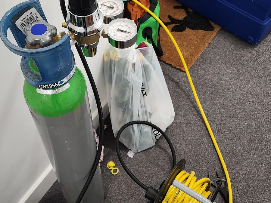 Pressure gauges and tracer gas equipment used during a Brighton bathroom leak investigation