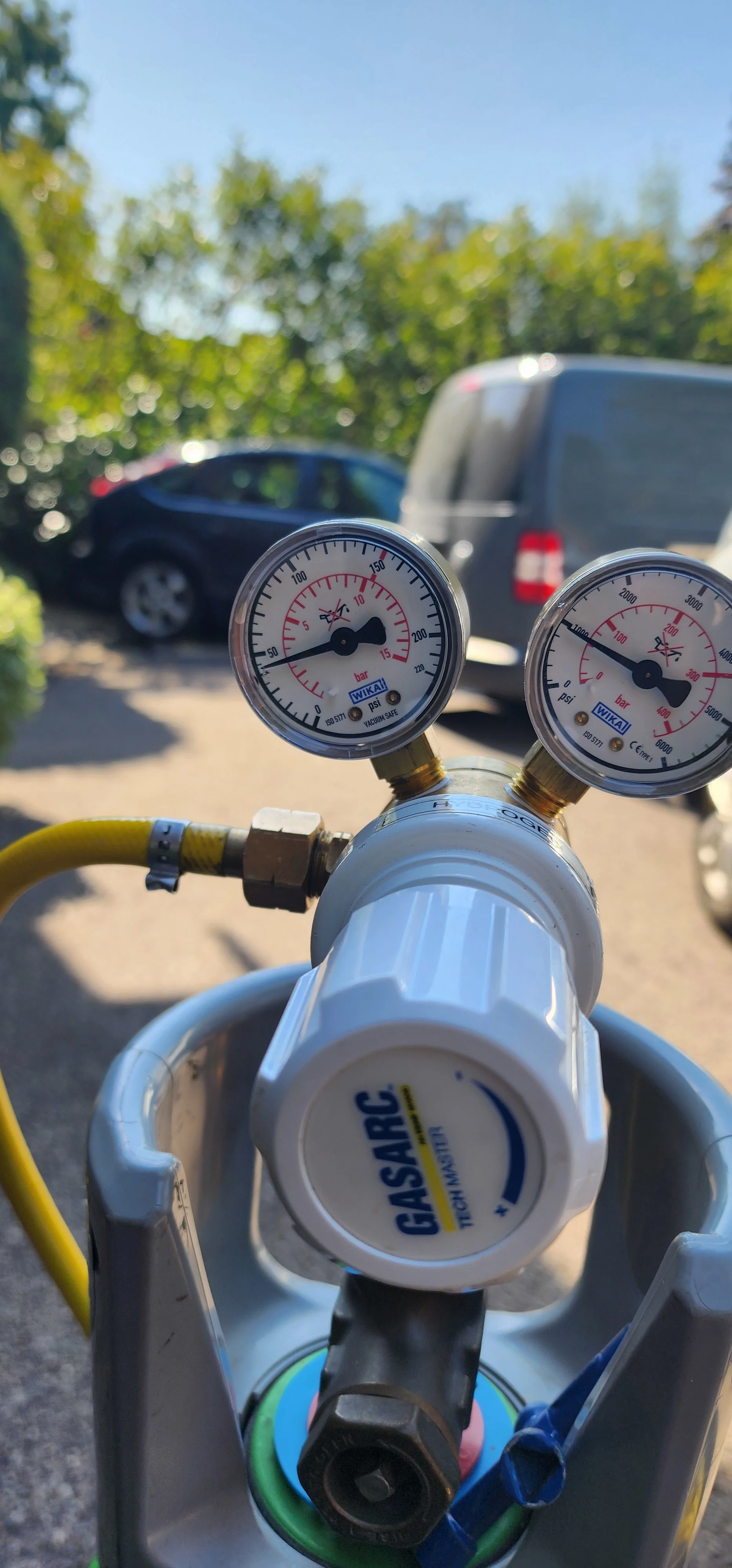Close-up of tracer gas cylinder regulator and pressure gauges outdoors