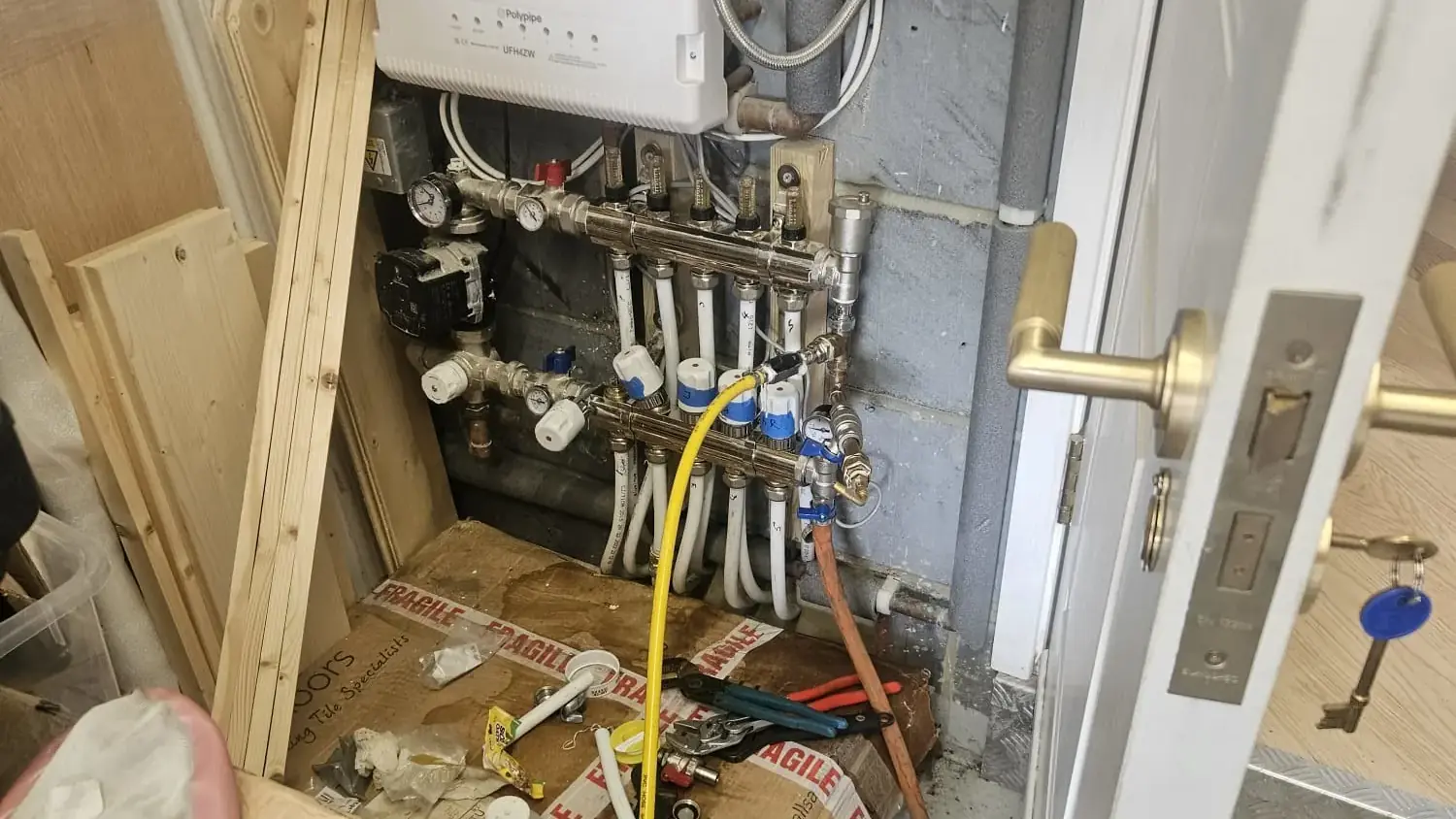 Underfloor heating manifold with a tracer gas line connected during the investigation